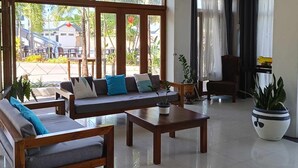 A spacious living area with a large sofa set, a coffee table, and a potted plant. - Marand Family Resort (Bauang)
