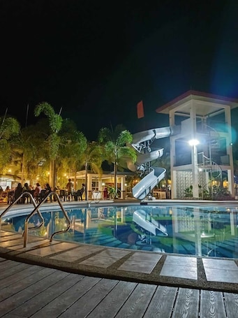 Una piscina al aire libre, sillones reclinables de piscina