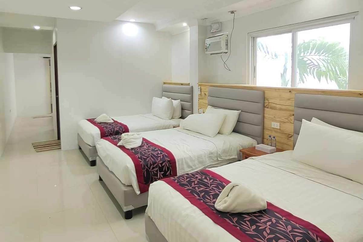 A modern hotel room with two beds, a large window with a view, and a ceiling with recessed lighting.