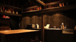 Eine schwach beleuchtete Küche mit Holdekor, einer Holz Arbeitsplatte und einer Mikrowelle.