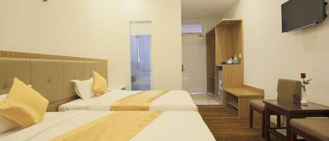 Habitación de hotel con dos camas, televisión, escritorio y silla.