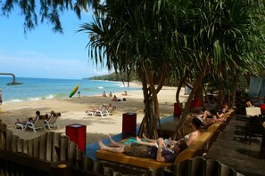 Di pantai, kursi berjemur, payung pantai, dan handuk pantai