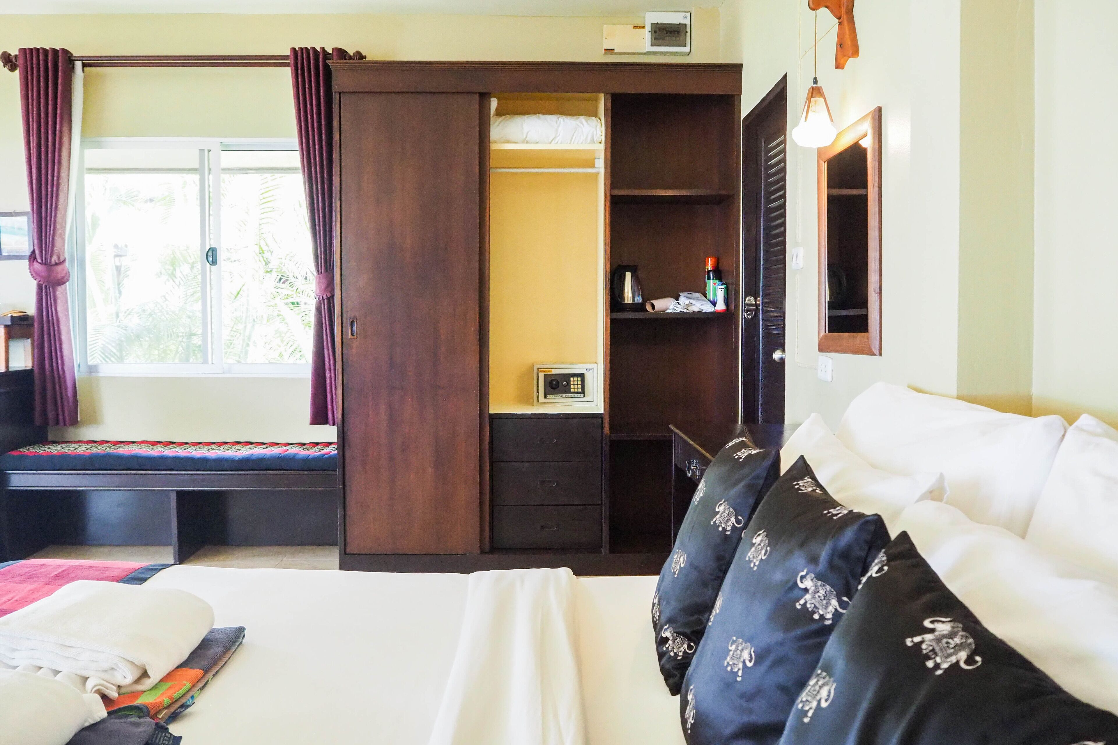 Ein Schlafzimmer mit Bett, Kleiderschrank, Schreibtisch und Fenster.