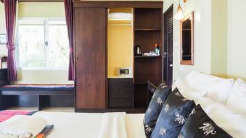 Ein Schlafzimmer mit Bett, Kleiderschrank, Schreibtisch und Fenster.