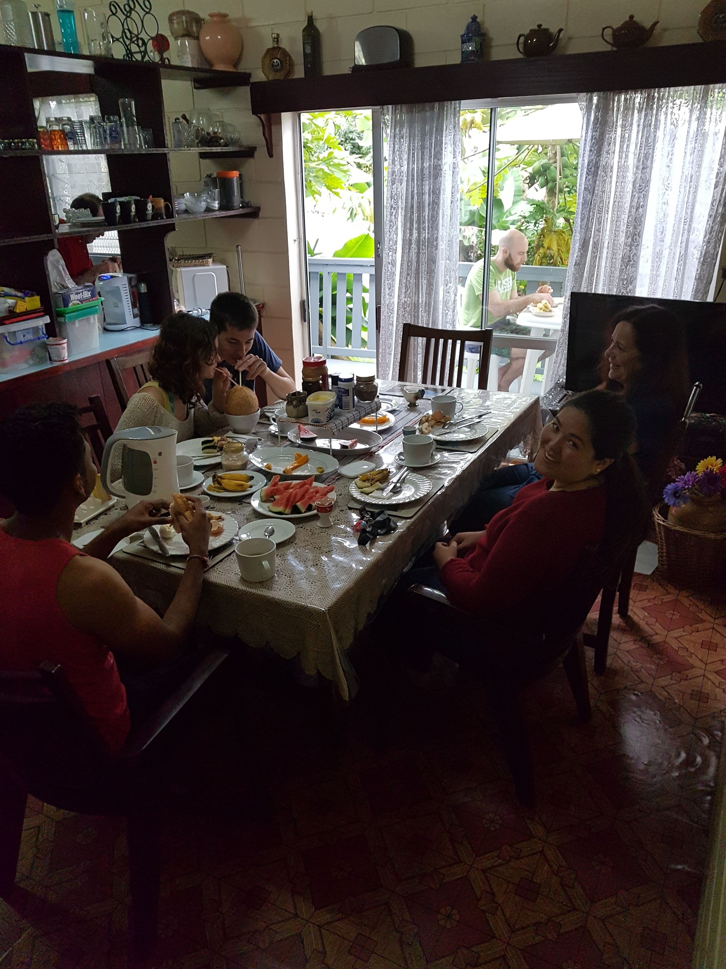 A dining area with a table set for a meal, surrounded by chairs.