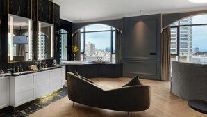 A modern bathroom with a large mirror, a vanity, and a bathtub. - The Granite Luxury Hotel Penang (George Town)
