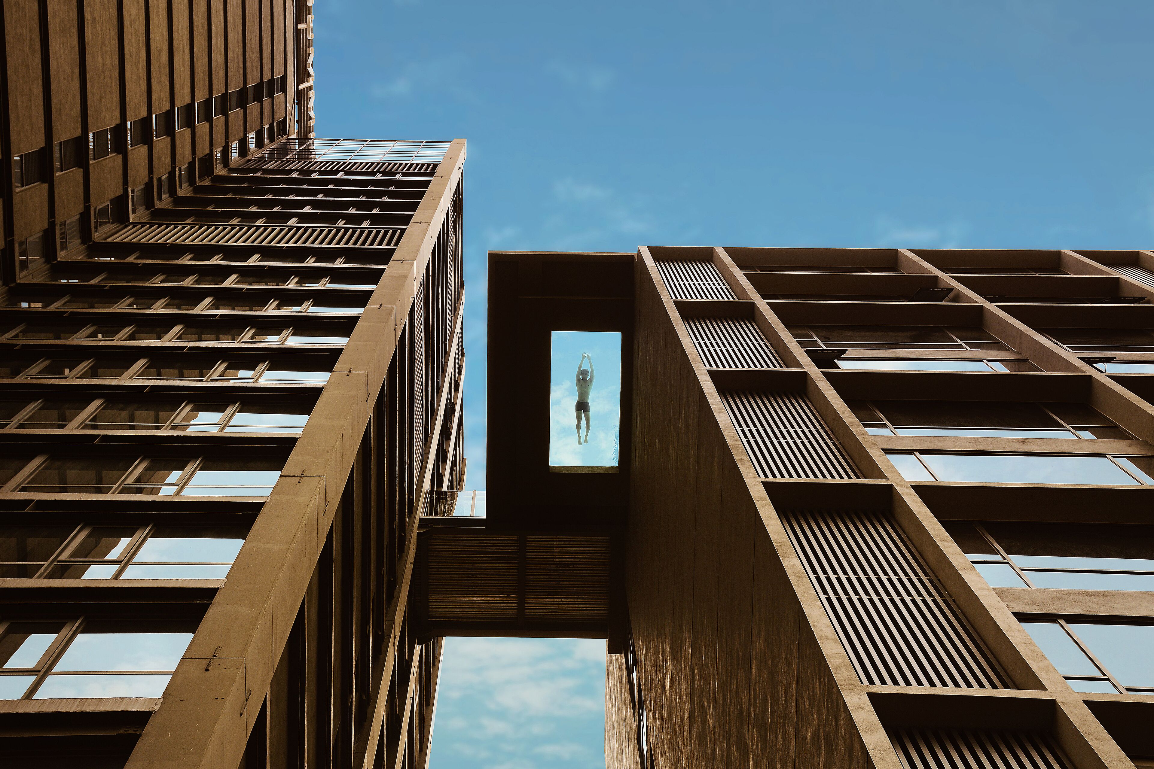 A modern building with a unique architectural design featuring a central void with a framed image.