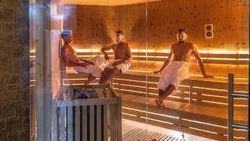 Eine Sauna mit Holzbänken und einer Glastrennwand.