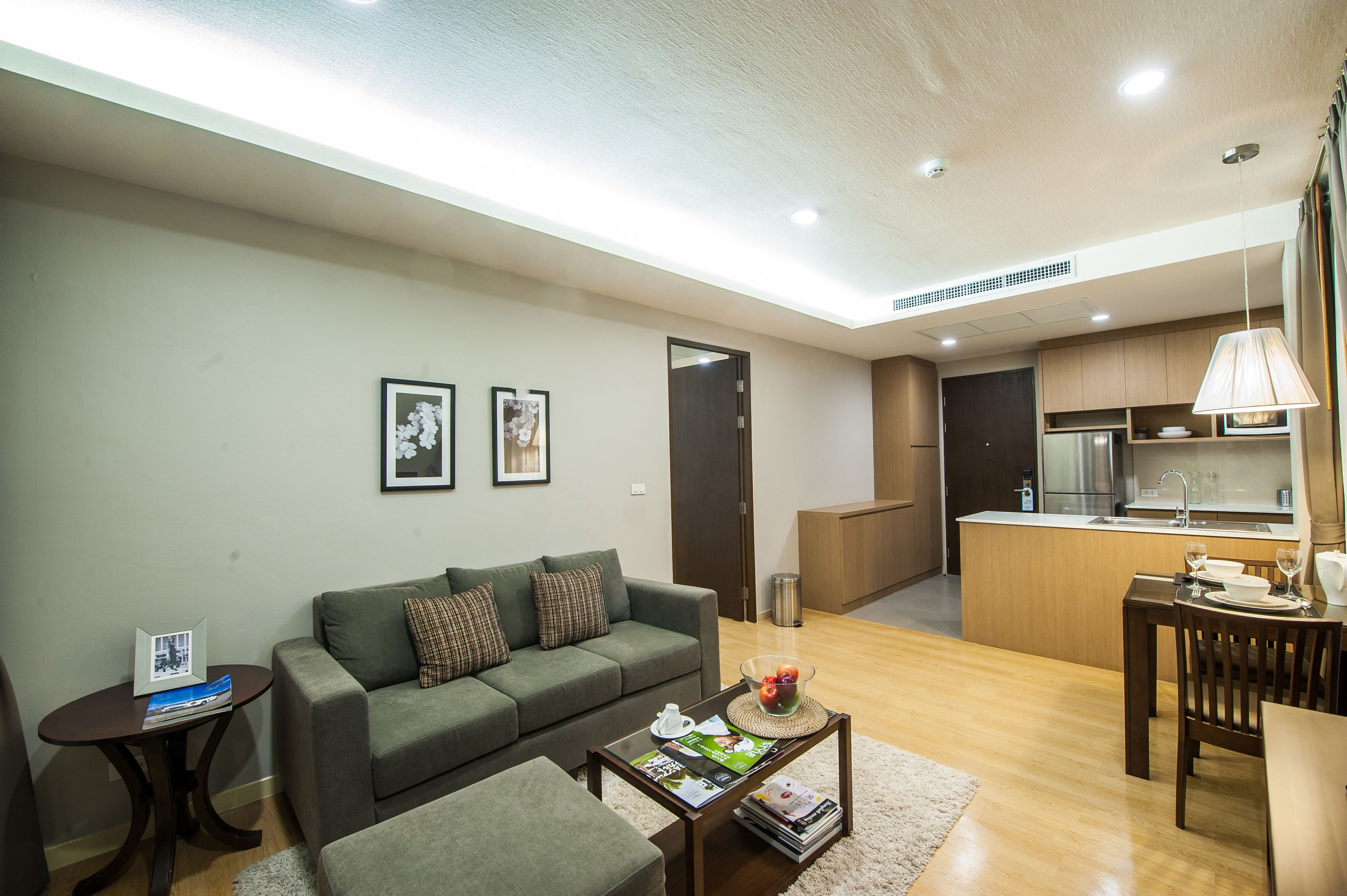 A modern living room with a sofa, coffee table, and a dining area with a table and chairs.