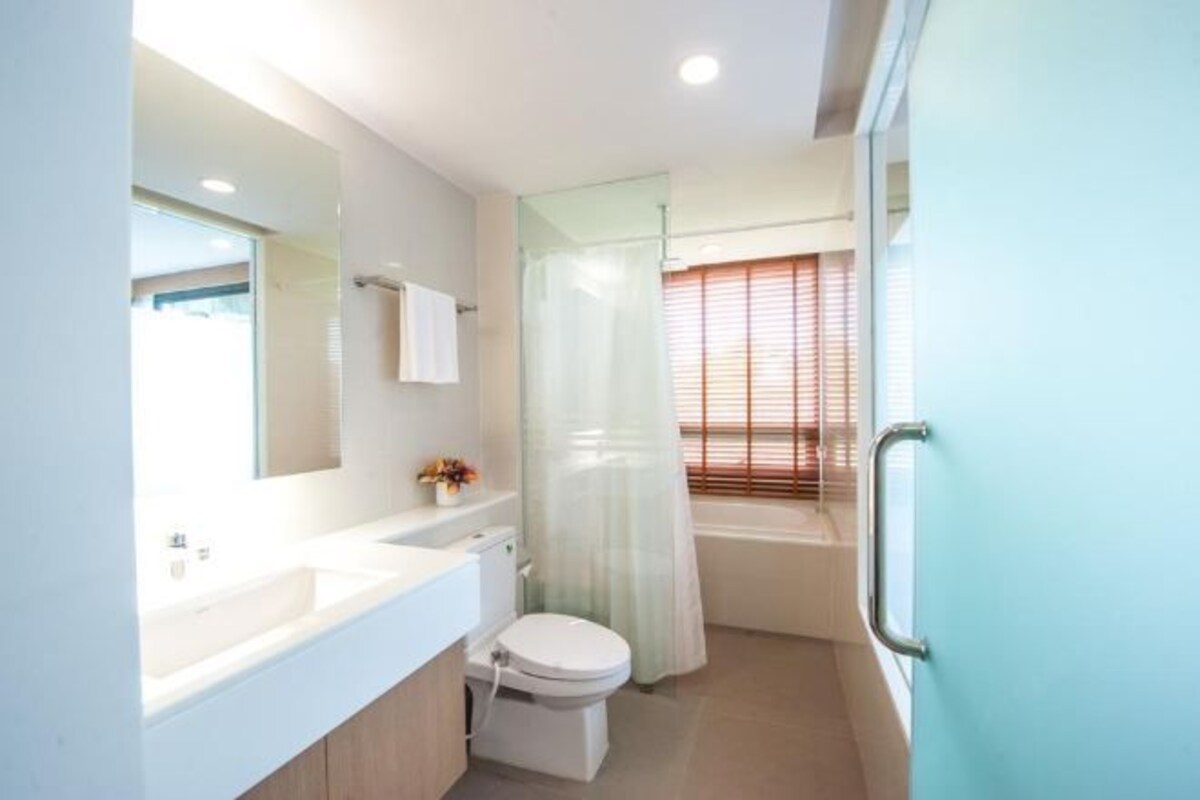 Un baño con inodoro, lavabo y zona de ducha.