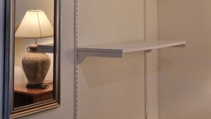 A mirror with a decorative frame, a lamp, and a wooden hanger on a wall. - Mookies Bungalow (Ko Mook)