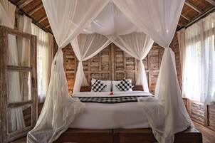 Una cama con dosel en una habitación rústica con paredes de madera.