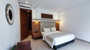 A bedroom with a bed, bedside tables, a wardrobe, an air conditioning unit, and a decorative wall piece. - De Umah Bali Eco Tradi Home (Tembuku)