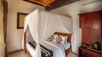 A bed with a canopy, a wooden wardrobe, and a tiled floor.