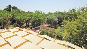 A garden with a wooden pergola structure. - Arsipel Hotel (Bozcaada)
