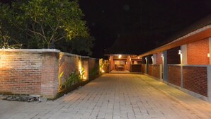 A brick building with a paved walkway leading to a covered entrance.
