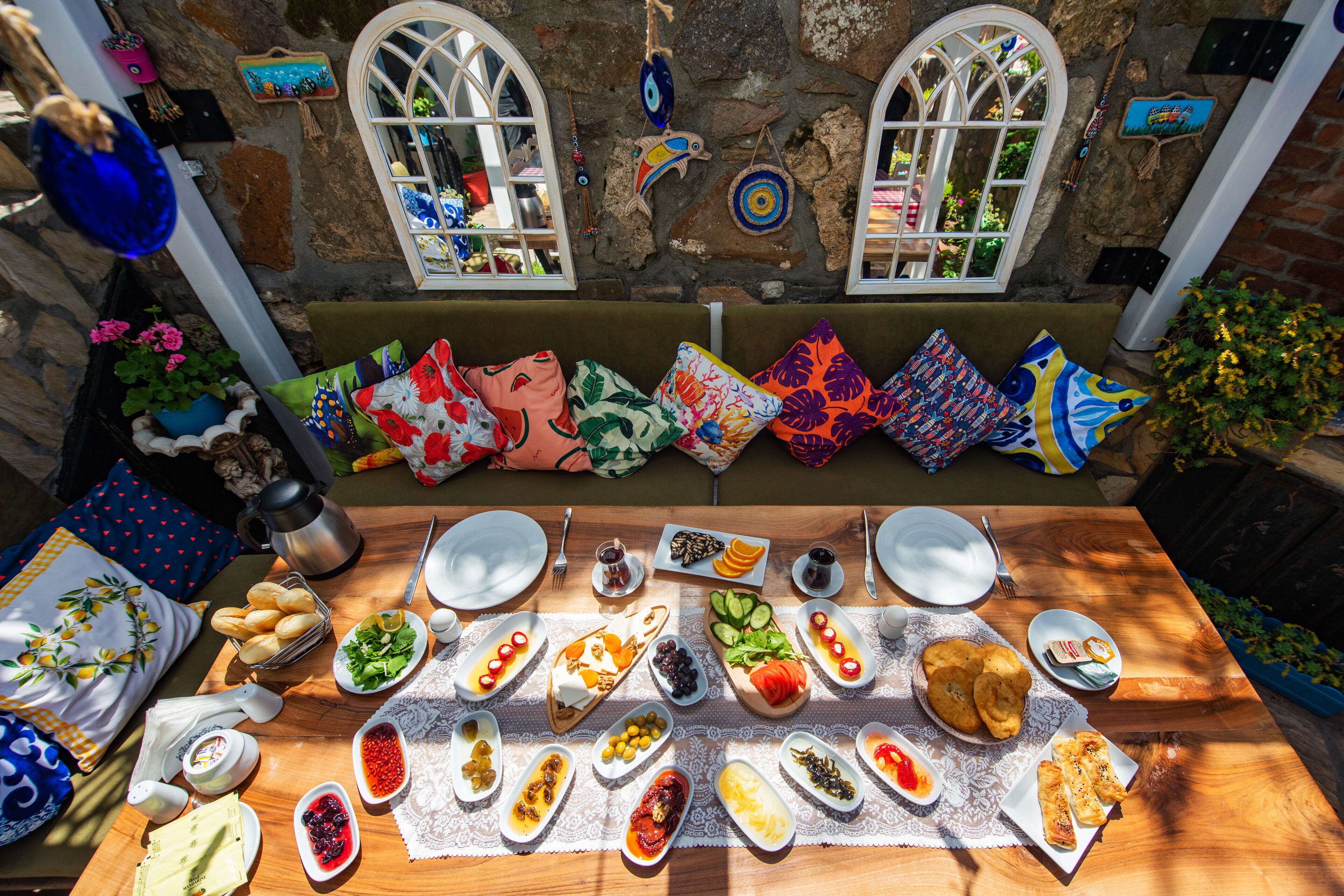 A table set with various dishes and a stone wall with windows.