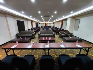 A conference room with rows of tables, chairs, and sofas. - Namira Syariah Hotel Surabaya (Surabaya)
