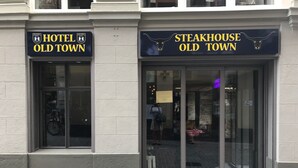 The entrance to Hotel Old Town and Steakhouse Old Town, featuring large glass doors and a brick facade. - Hotel Old Town (Zürich)