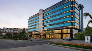 A modern hotel with a prominent vertical sign, multiple floors, and a well-maintained outdoor area with landscaping and a parking lot. - Ramada Plaza by Wyndham Samsun (Samsun)