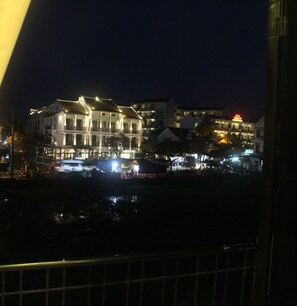A waterfront hotel with multiple stories, balconies, and a prominent restaurant sign. - Hoi An Green View Homestay (Da Nang)