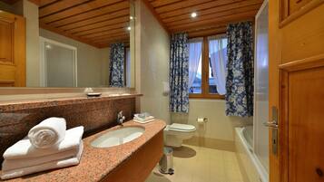 Ein Badezimmer mit Granitplatte, Waschbecken, Toilette und Badewanne.