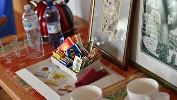 A table with a tea set, water bottles, a kettle, and a framed picture.