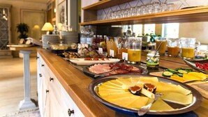 A buffet with various food items and beverages, including fruits, cheeses, and meats. - STADT-Hotel Lörrach (Loerrach)