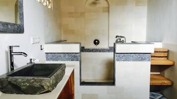 Une salle de bain avec deux lavabos, un grand miroir et une douche.