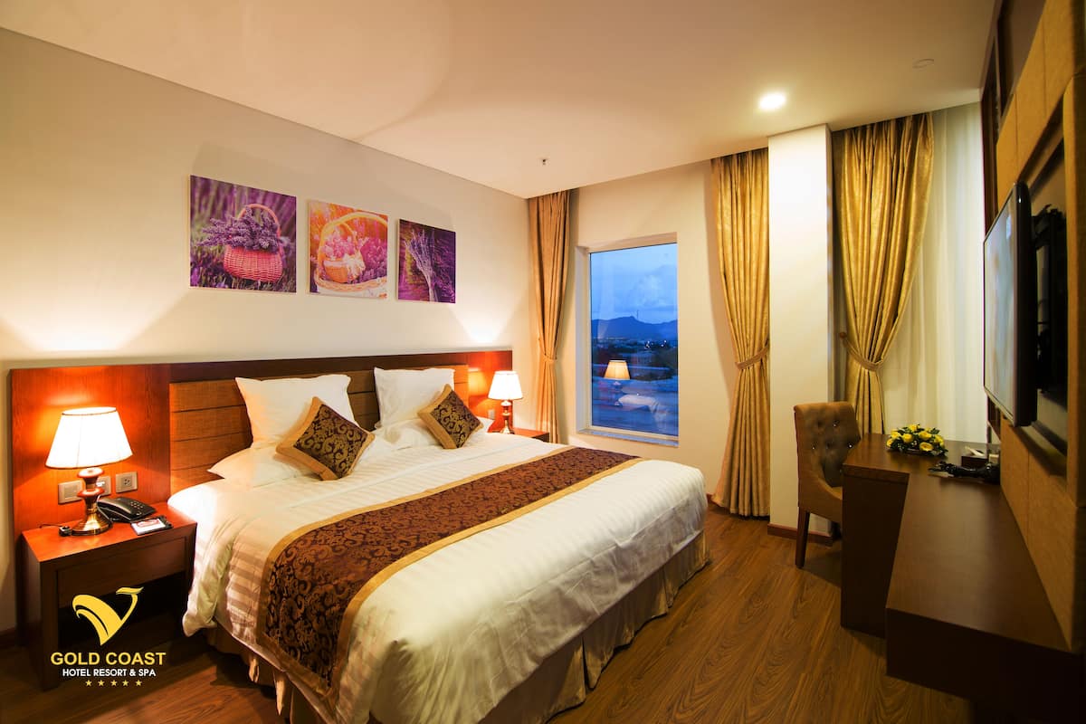 Une chambre d’hôtel avec un grand lit, un bureau, une chaise et une vue sur les montagnes.
