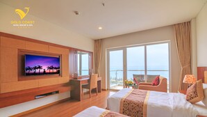 Een hotelkamer met twee bedden, een televisie, een bureau en een balkon met uitzicht.