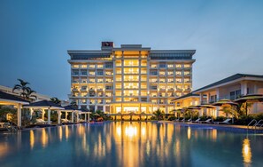 A large hotel with multiple floors, a swimming pool, and outdoor seating areas. - Gold Coast Hotel Resort & Spa (Dong Hoi)