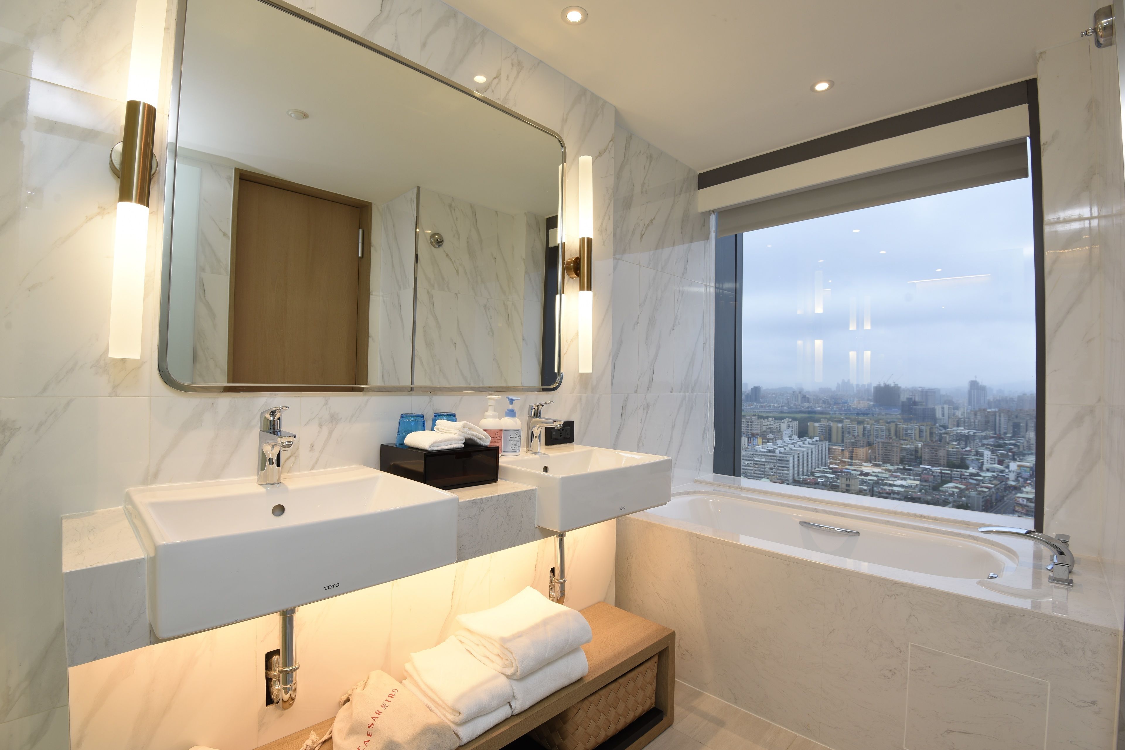 Un baño moderno con dos lavamanos, un espejo grande y una bañera.