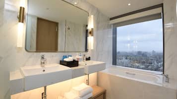Un baño moderno con dos lavamanos, un espejo grande y una bañera.