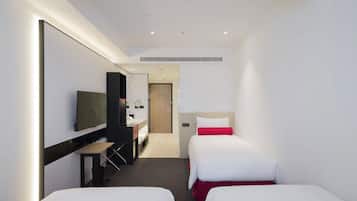 Habitación de hotel con dos camas, un escritorio, un televisor y un espejo.