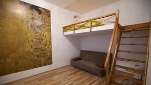 A room with a bunk bed, a large painting on the wall, and a wooden floor. - Klimt Apartments (Vienna)