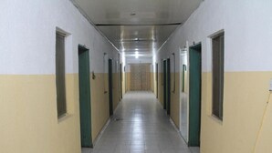 A long, narrow hallway with doors on both sides, leading to individual rooms. - Yaban Hotel (Abuja)