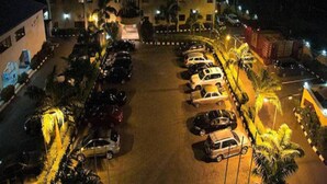 Un hotel con parcheggio, diversi piani e un cartello che indica che si tratta di un albergo.