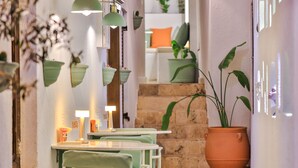 A cozy indoor seating area with a table, chairs, and hanging planters.