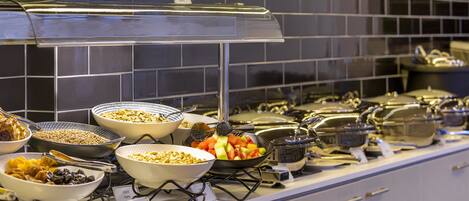 A buffet with various food items and cooking equipment.