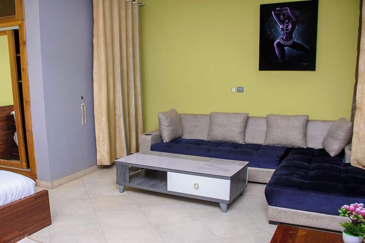 A room with a bed, a sofa, a coffee table, and a cabinet.