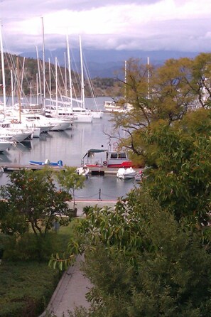 A marina with multiple boats docked, surrounded by greenery and hills in the background. - Pinara Pension & Guesthouse (Fethiye)