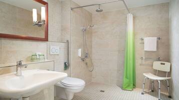 Un baño moderno con lavamanos, inodoro, ducha y una silla.