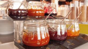 A beverage station with multiple glass jars containing different colored drinks, each with a straw.