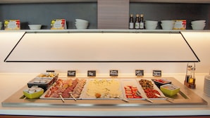 Ein Buffet mit verschiedenen Speisen und Schildern, die die einzelnen Bereiche kennzeichnen.