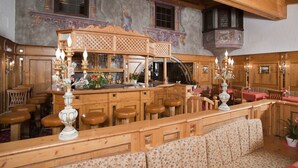 A wooden interior with a bar area, seating, and decorative elements. - Hotel Alpenhof Grainau (Grainau)