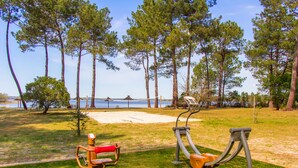 Outdoor exercise equipment in a park with a beach and trees in the background. - Azureva Lacanau (Lacanau)