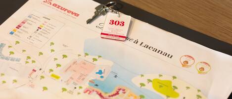 A hotel brochure with a map, key, and a tag with the number 303.