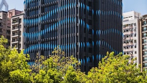 Un edificio alto y moderno con una fachada distintiva azul y negra, identificado como "H2O Hotel".