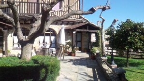 Un bâtiment traditionnel doté d’une façade en pierre, de balcons en bois et d’espaces de détente en plein air.